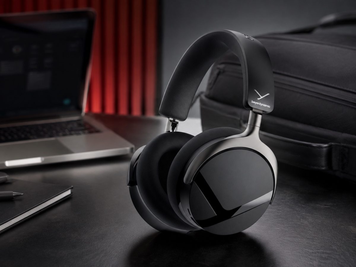 Exact black Beyerdynamic Aventho Y headphones on a work-and-travel desk in an editorial illustration