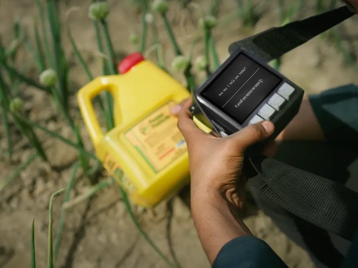 Official Suno Sutra handheld AI device used in an agricultural field, representing VYOMA Challenge offline prototypes